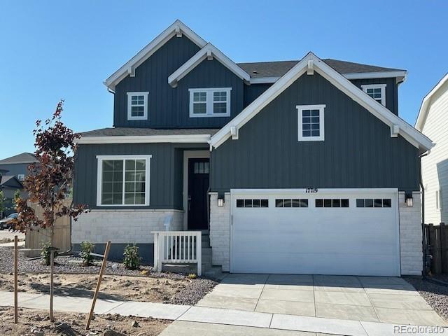 17719 Prairie Peak Trl, Parker, CO 80134 - view of front of house featuring driveway, board and batten siding, and stone siding