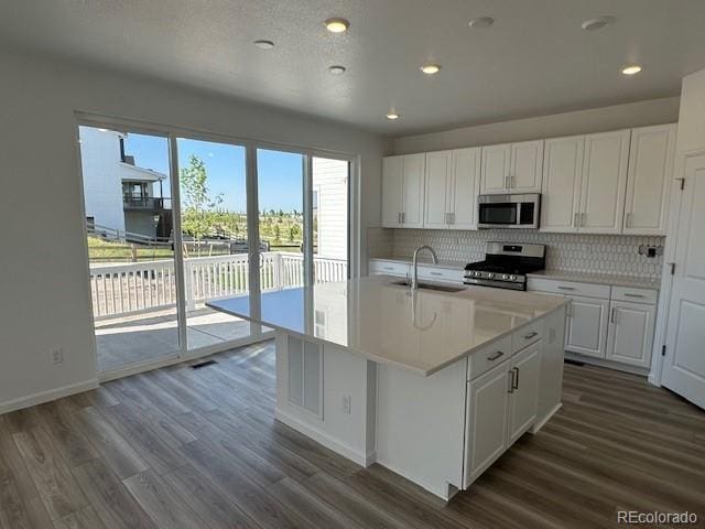 17719 Prairie Peak Trl, Parker, CO 80134 - kitchen with appliances with stainless steel finishes, decorative backsplash, white cabinetry, and recessed lighting