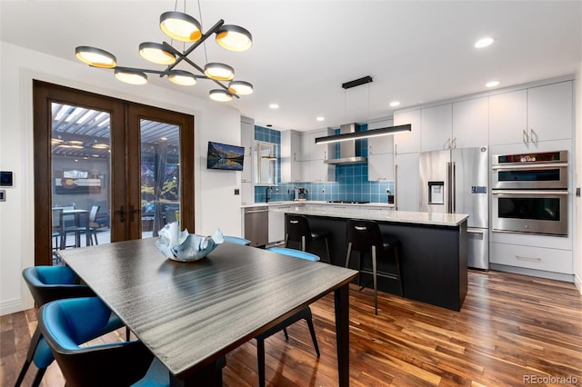 dining space featuring an inviting chandelier, dark wood-type flooring, and french doors