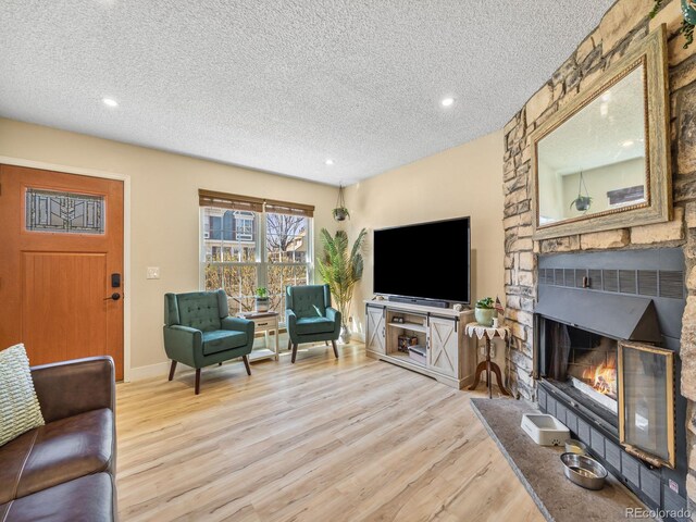 1247 S Idalia St, Aurora, CO 80017 - living area featuring a textured ceiling, wood finished floors, recessed lighting, a fireplace, and baseboards