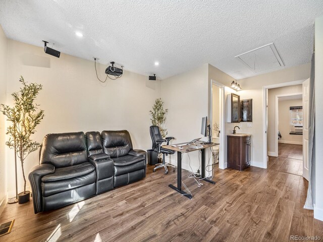1247 S Idalia St, Aurora, CO 80017 - living area with a textured ceiling, wood finished floors, baseboards, attic access, and recessed lighting