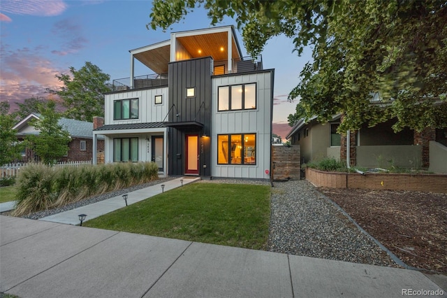 modern home featuring a balcony and a lawn