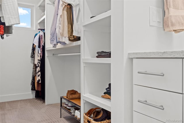 walk in closet featuring light colored carpet