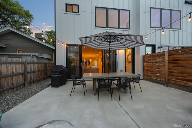 patio terrace at dusk featuring a grill