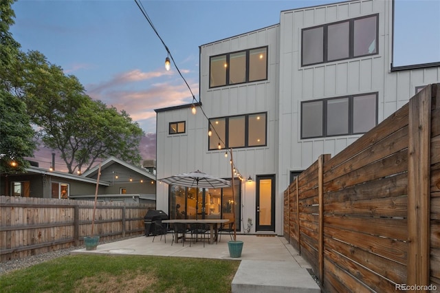 back house at dusk with a patio