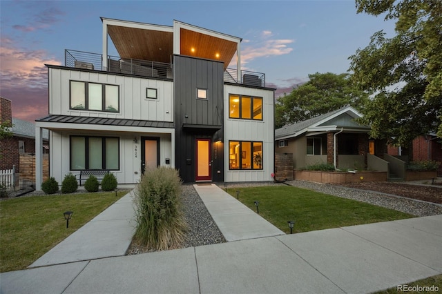 contemporary home with a yard and a balcony