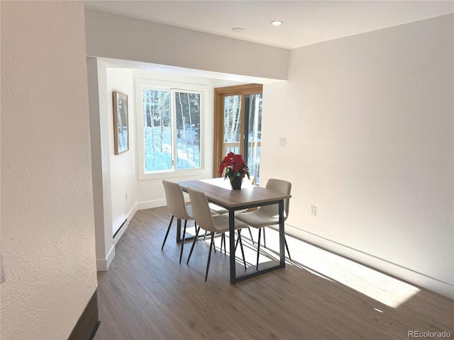 dining area with baseboard heating and dark hardwood / wood-style flooring