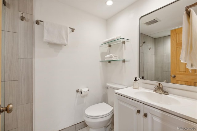 bathroom featuring vanity, toilet, and a shower