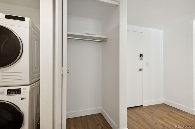 washroom with stacked washer and dryer and light hardwood / wood-style flooring