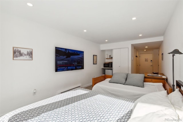 bedroom featuring a closet and a baseboard heating unit