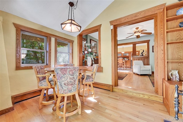 dining area featuring light hardwood / wood-style floors, lofted ceiling, and ceiling fan