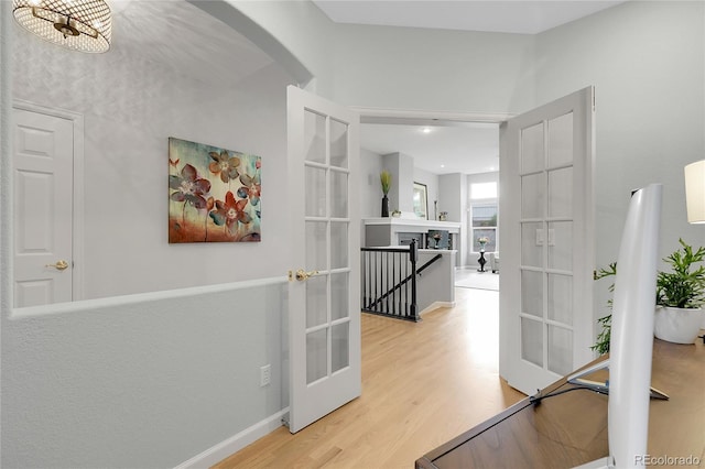 1033 Bramblewood Dr, Castle Pines, CO 80108 - corridor featuring arched walkways, wood finished floors, and french doors