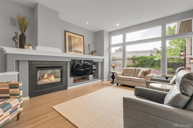 1033 Bramblewood Dr, Castle Pines, CO 80108 - living area featuring a tile fireplace, wood finished floors, and recessed lighting
