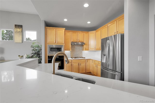 1033 Bramblewood Dr, Castle Pines, CO 80108 - kitchen with appliances with stainless steel finishes, light brown cabinetry, recessed lighting, under cabinet range hood, and tasteful backsplash