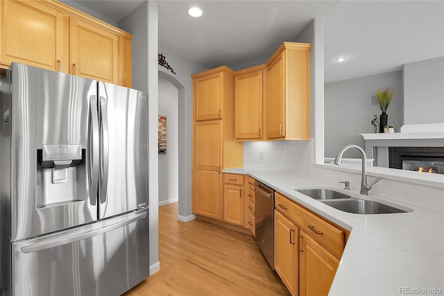 1033 Bramblewood Dr, Castle Pines, CO 80108 - kitchen featuring appliances with stainless steel finishes, light wood-style flooring, recessed lighting, arched walkways, and light brown cabinets