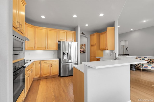 1033 Bramblewood Dr, Castle Pines, CO 80108 - kitchen with appliances with stainless steel finishes, light brown cabinets, light wood finished floors, a peninsula, and recessed lighting