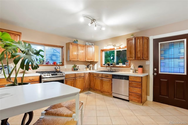 4210 S Fox St, Englewood, CO 80110 - kitchen featuring appliances with stainless steel finishes, a sink, light countertops, light tile patterned flooring, and brown cabinets