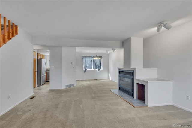 8911 W Yale Ave, Lakewood, CO 80227 - unfurnished living room featuring a notable chandelier, visible vents, and light colored carpet