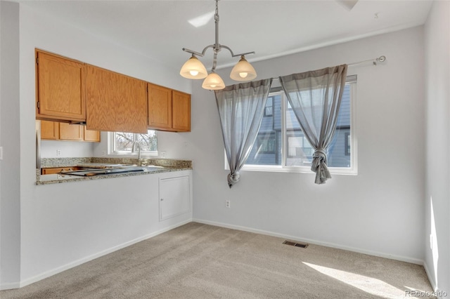 8911 W Yale Ave, Lakewood, CO 80227 - kitchen with brown cabinets, light countertops, decorative light fixtures, and baseboards