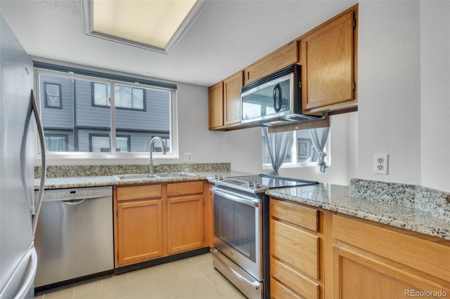 8911 W Yale Ave, Lakewood, CO 80227 - kitchen featuring stainless steel appliances, brown cabinets, a sink, and light stone countertops
