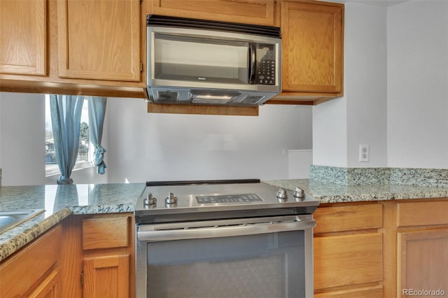 8911 W Yale Ave, Lakewood, CO 80227 - kitchen with light stone countertops and stainless steel appliances