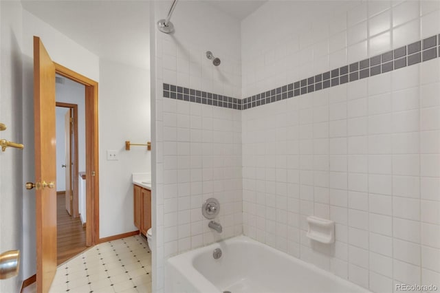 8911 W Yale Ave, Lakewood, CO 80227 - bathroom with bathing tub / shower combination, toilet, vanity, baseboards, and tile patterned floors