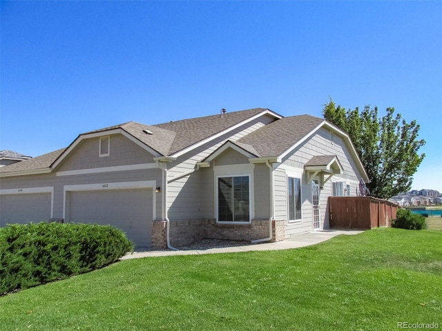 view of front of property featuring a garage, a shingled roof, fence, a front yard, and brick siding