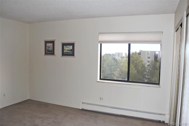 carpeted empty room featuring a textured ceiling and a baseboard heating unit