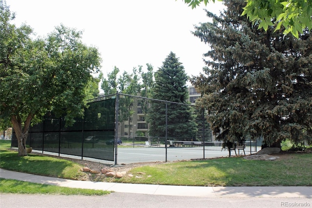 view of tennis court with a yard