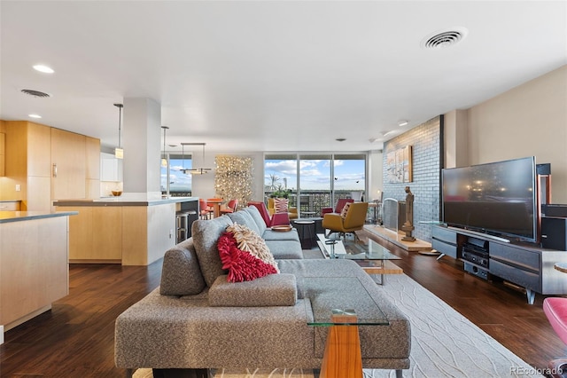 living room with a wall of windows, visible vents, and dark wood-type flooring