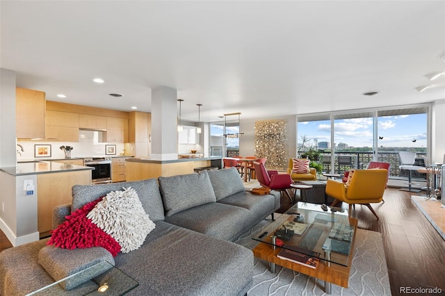 living area with recessed lighting, expansive windows, baseboards, and wood finished floors