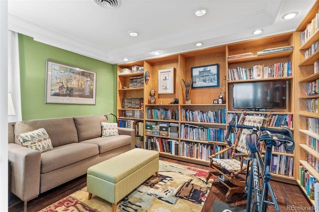 living area with visible vents, built in shelves, wood finished floors, recessed lighting, and crown molding