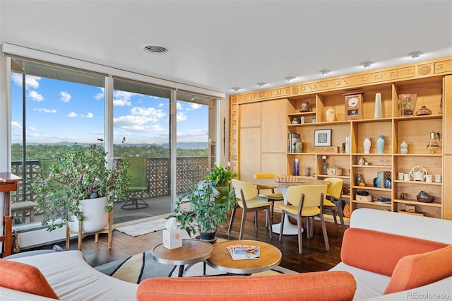 living room featuring visible vents, wood finished floors, and floor to ceiling windows