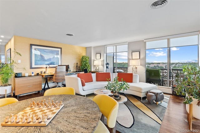 living area featuring visible vents, wood finished floors, and floor to ceiling windows