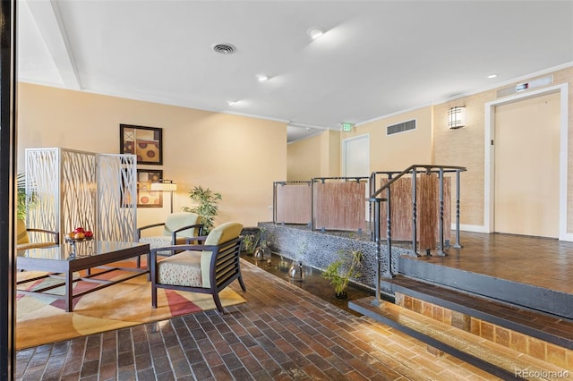 office space with visible vents, crown molding, and brick floor