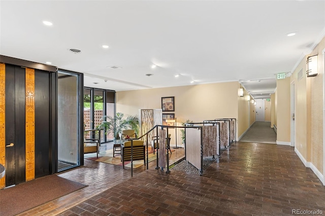 corridor with baseboards, recessed lighting, brick floor, expansive windows, and an upstairs landing