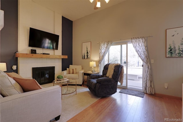 8217 Club Crest Dr, Arvada, CO 80005 - living area with high vaulted ceiling, wood finished floors, a brick fireplace, and ceiling fan