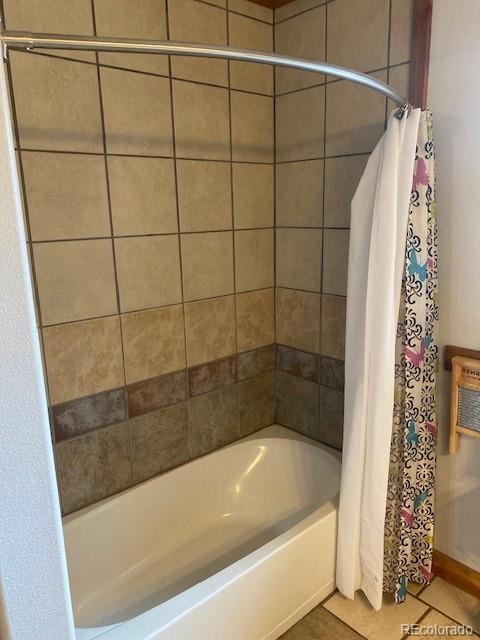 bathroom with tile patterned floors and shower / bathtub combination with curtain