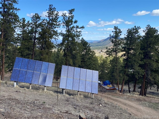 view of property exterior with a mountain view and solar panels