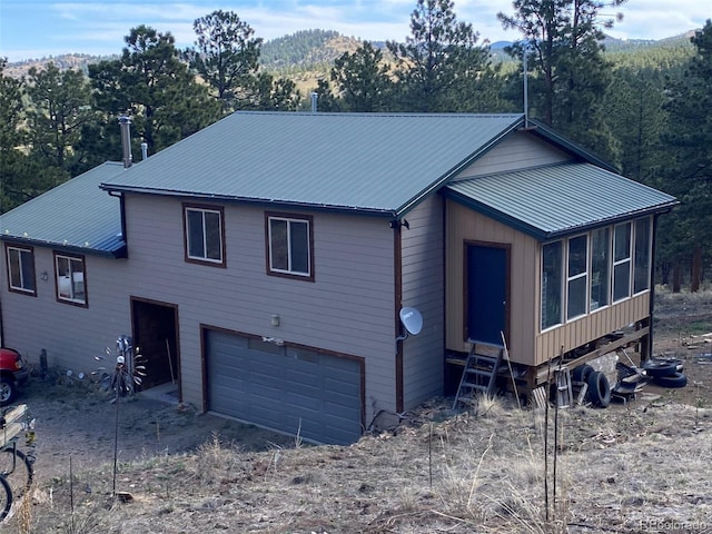 view of front of property with a garage and a sunroom