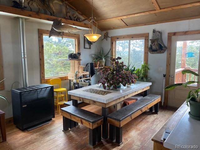 dining area with hardwood / wood-style flooring, vaulted ceiling, and plenty of natural light