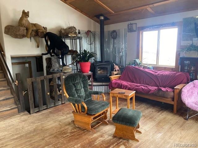 bedroom with hardwood / wood-style floors and a wood stove