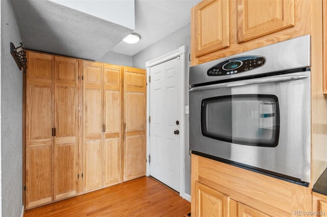 1206 Baldwin Park Cir, Castle Rock, CO 80104 - kitchen featuring stainless steel oven, light wood-style flooring, and light brown cabinetry