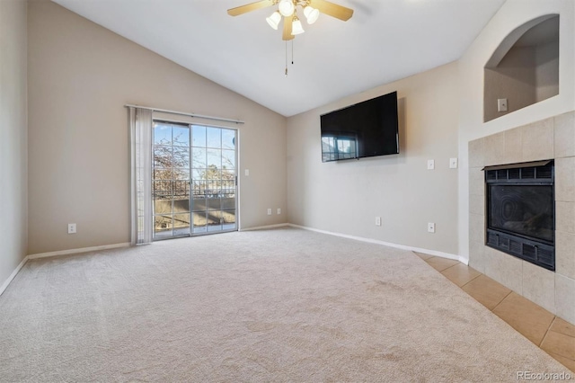 unfurnished living room with high vaulted ceiling, ceiling fan, light tile patterned floors, and a tile fireplace