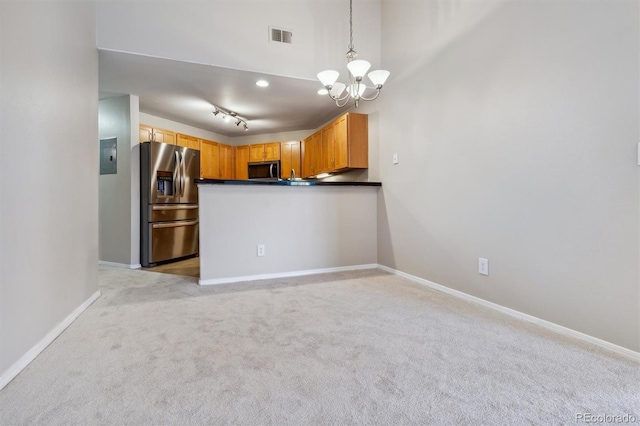 kitchen with light carpet, hanging light fixtures, appliances with stainless steel finishes, and track lighting