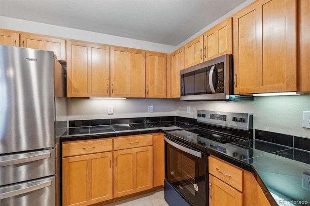 kitchen with light tile patterned floors and stainless steel appliances