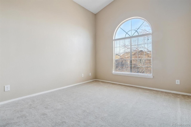 carpeted spare room with vaulted ceiling and plenty of natural light