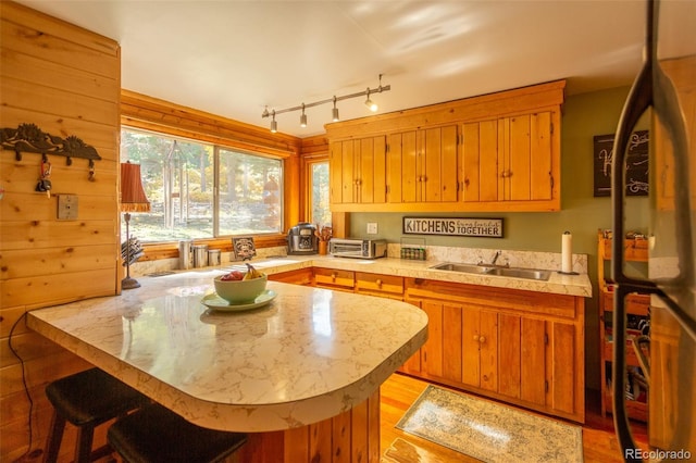 4745 Forest Ln, Howard, CO 81233 - kitchen featuring a sink, light countertops, a peninsula, brown cabinetry, and a kitchen bar