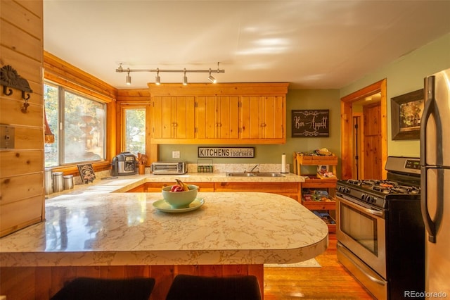 4745 Forest Ln, Howard, CO 81233 - kitchen featuring gas stove, a sink, light countertops, a peninsula, and light wood-style flooring