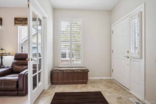 foyer entrance featuring baseboards and a wealth of natural light